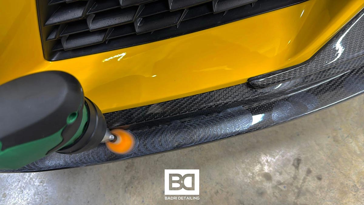 Polissage du pare-chocs en carbone d’une voiture jaune par Badri Detailing